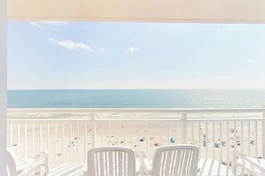 A balcony with white chairs and a view of the beach. - Bay Watch Resort 1102 Oceanfront (North Myrtle Beach)