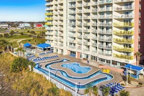 A multi-story hotel with a swimming pool, outdoor seating, and balconies. - Bay Watch Resort 1102 (North Myrtle Beach)