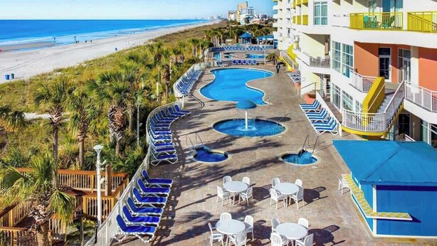 A resort with a pool area, beach view, and multiple balconies. - Bay Watch Resort 1135 (North Myrtle Beach)