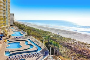 Ein Resort mit mehreren Schwimmbecken und Blick auf den Strand.