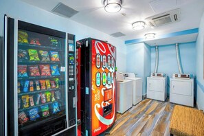 Ein Zimmer mit Automaten, Waschmaschine und Trockner.