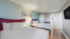 Ein Hotelzimmer mit zwei Betten, einem Nachttisch mit Lampe und einem Wandbild.