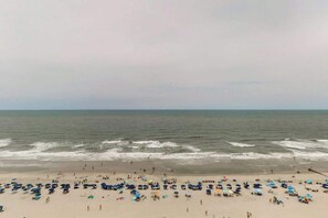 Ein Strand mit vielen Sonnenschirmen und Menschen.