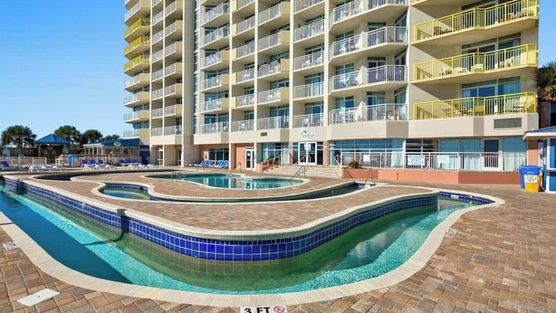 Un hôtel à plusieurs étages doté d’un espace piscine dont le bassin présente un tracé sinueux.