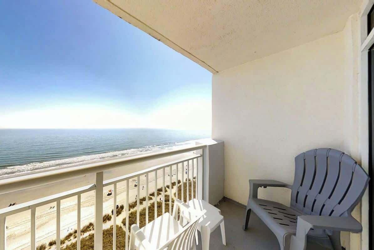 Ein Balkon mit Blick auf Strand und Meer.
