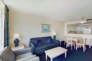 Ein Wohnzimmer mit einer Couch, einem Couchtisch und einem Essbereich mit Stühlen und einem Tisch.