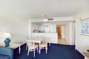 A compact living space with a dining area, kitchenette, and a small seating area. - Bay Watch Resort 1412 (North Myrtle Beach)
