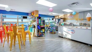 An ice cream shop interior with seating, a display case, and various items on shelves. - Bay Watch Resort 1501 (North Myrtle Beach)
