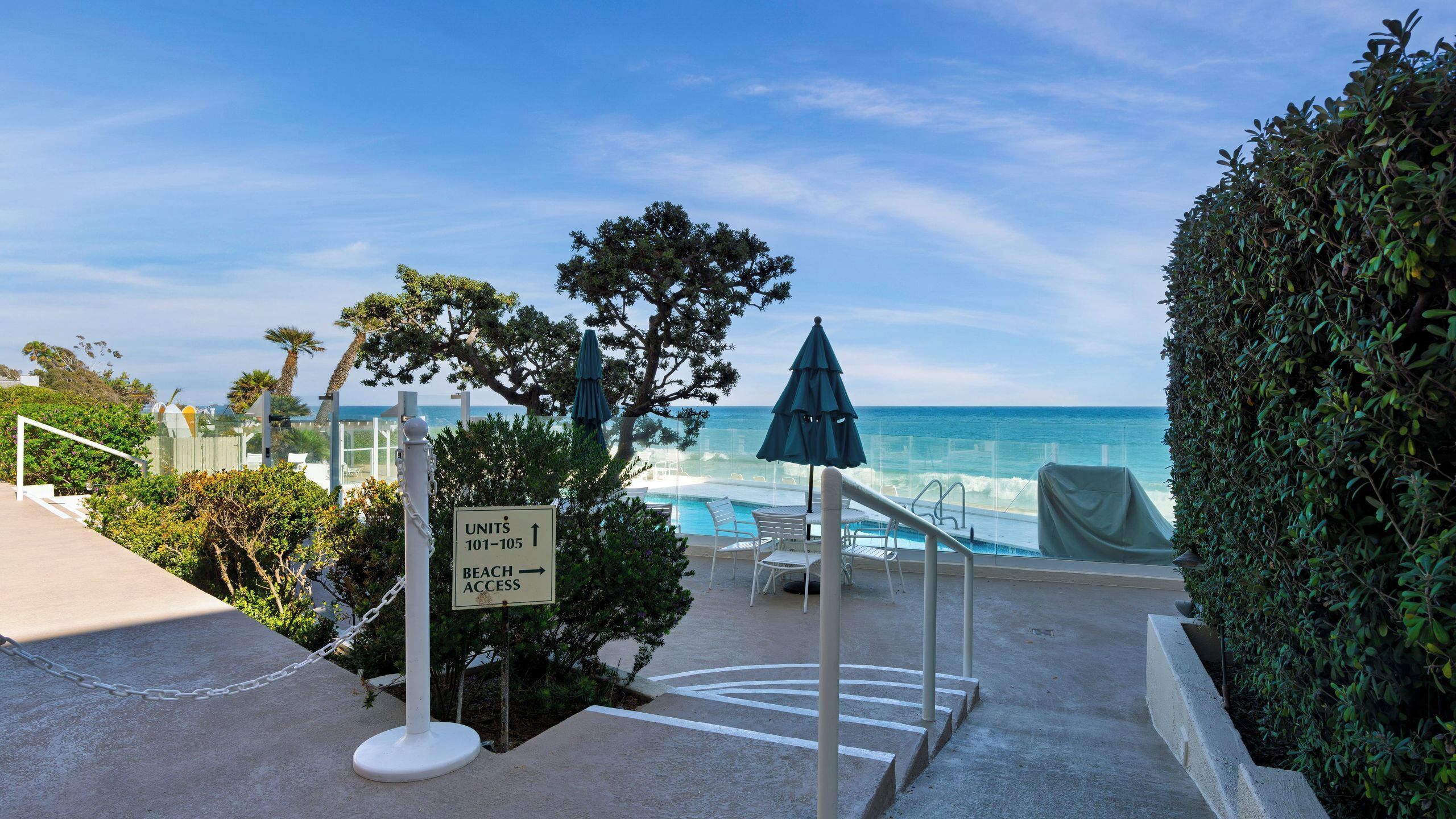 A pool area with a sign indicating units 101-105 and beach access.