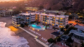 A hotel with multiple floors, a swimming pool, and a beachside location.