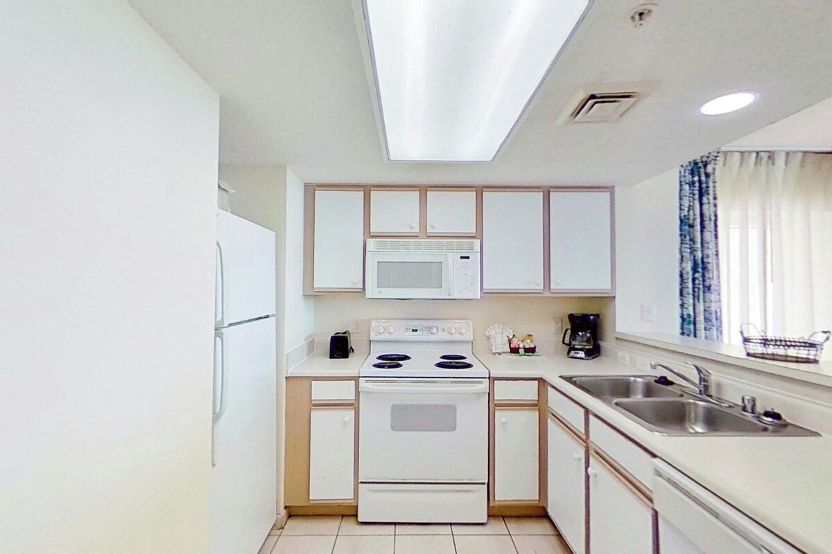 Cocina compacta con microondas, estufa y lavabo.