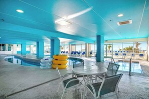 A swimming pool area with lounge chairs and a table. - Bay Watch Resort 1613 (North Myrtle Beach)