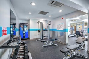 A gym with exercise equipment, including dumbbells, benches, and a weight machine. - Bay Watch Resort 1613 (North Myrtle Beach)