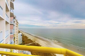 Ein Hochhaus mit Balkonen mit Blick auf einen Strand.