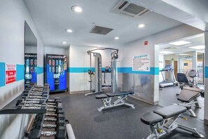 A gym with exercise equipment, including dumbbells, benches, and a weight machine. - Bay Watch Resort 1809 (North Myrtle Beach)