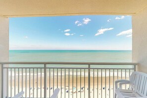 Uma varanda com vista para a praia e o oceano.