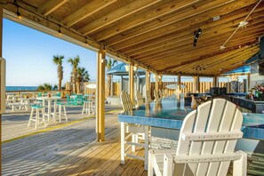 An outdoor wooden deck with tables and chairs, overlooking the ocean. - Bay Watch Resort 1906 (North Myrtle Beach)
