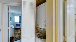 Une buanderie équipée d’un lave-linge et d’un sèche-linge, d’une chaise et d’une petite table.