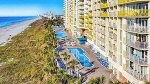 A hotel with multiple swimming pools, a beach view, and a high-rise building. - Bay Watch Resort 1921 (North Myrtle Beach)
