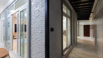 Un pasillo moderno con puertas de vidrio, una pared de ladrillo decorativa y suelo de baldosas.