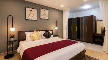 Un dormitorio moderno con una cama grande, mesitas de noche, un armario y un escritorio con silla.