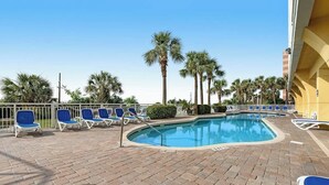 A pool area with lounge chairs and palm trees. - Camelot by the Sea 0307 (Myrtle Beach)
