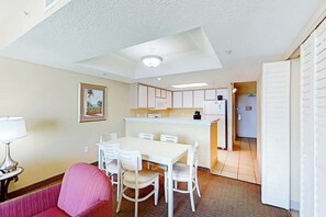 Un espace de vie compact comprenant un coin repas, une kitchenette et un petit coin salon.