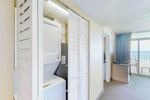 Ein Hotelzimmer mit großem Fenster, Balkon und Schrank mit Schiebetür.