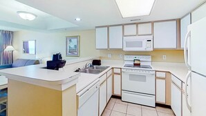 Une cuisine moderne avec des meubles blancs, un four à micro-ondes, une cuisinière et un réfrigérateur.