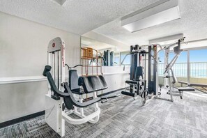 Une salle de sport équipée de matériel d’exercice, dotée d’un miroir et offrant une vue sur l’extérieur.