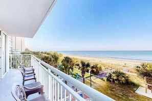 Ein Balkon mit Blick auf den Strand und den Ozean.