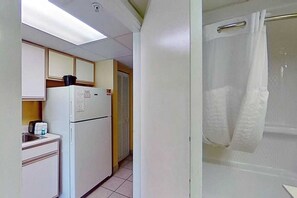 Eine kleine Küche mit Kühlschrank, Spüle und einer Arbeitsfläche.