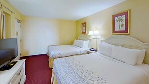 A hotel room with two beds, a television, and artwork on the walls. - Camelot by the Sea 0516 (Myrtle Beach)