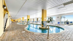 Ein Hallenbad mit Liegestühlen und Blick auf den Ozean.