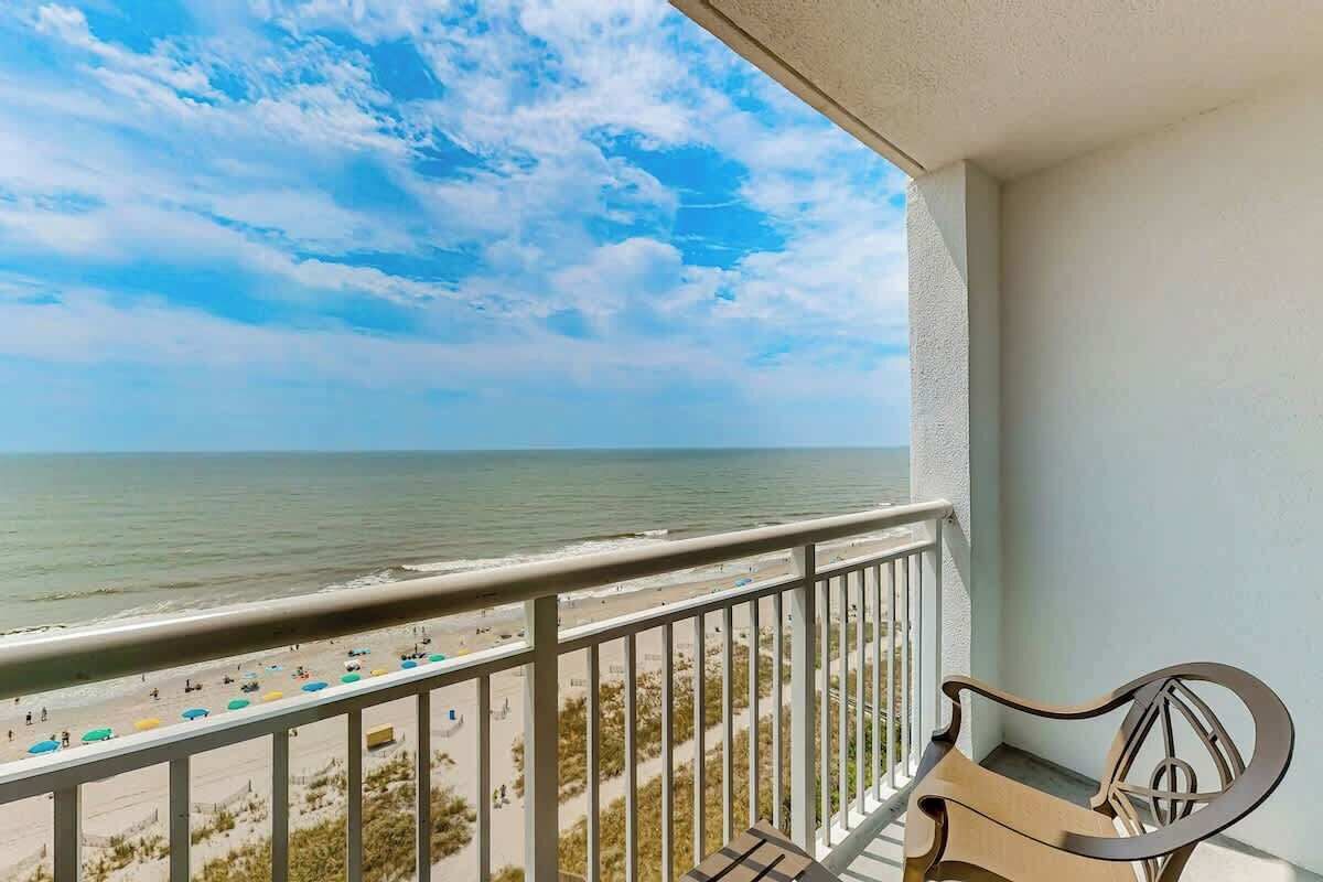 Un balcon avec vue sur la plage et l’océan.