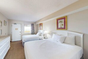 A hotel room with two beds, a dresser, and a door leading to another room. - Camelot by the Sea 1214 (Myrtle Beach)