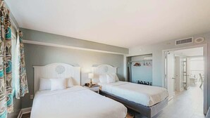 A hotel room with two beds, a bathroom with a shower, and a walk-in closet with hanging clothes. - Camelot by the Sea 1207 (Myrtle Beach)