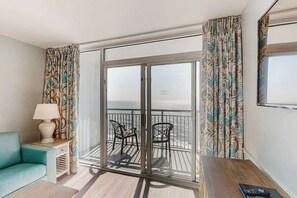 A balcony with a view of the sea, a sofa, a lamp, and a table. - Camelot by the Sea 1207 (Myrtle Beach)