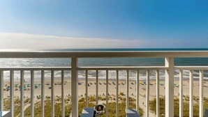 Ein Balkon mit Blick auf einen Strand, inklusive Meer und Sandküste.