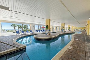 Ein Hallenbad mit Liegestühlen und Blick auf den Ozean.