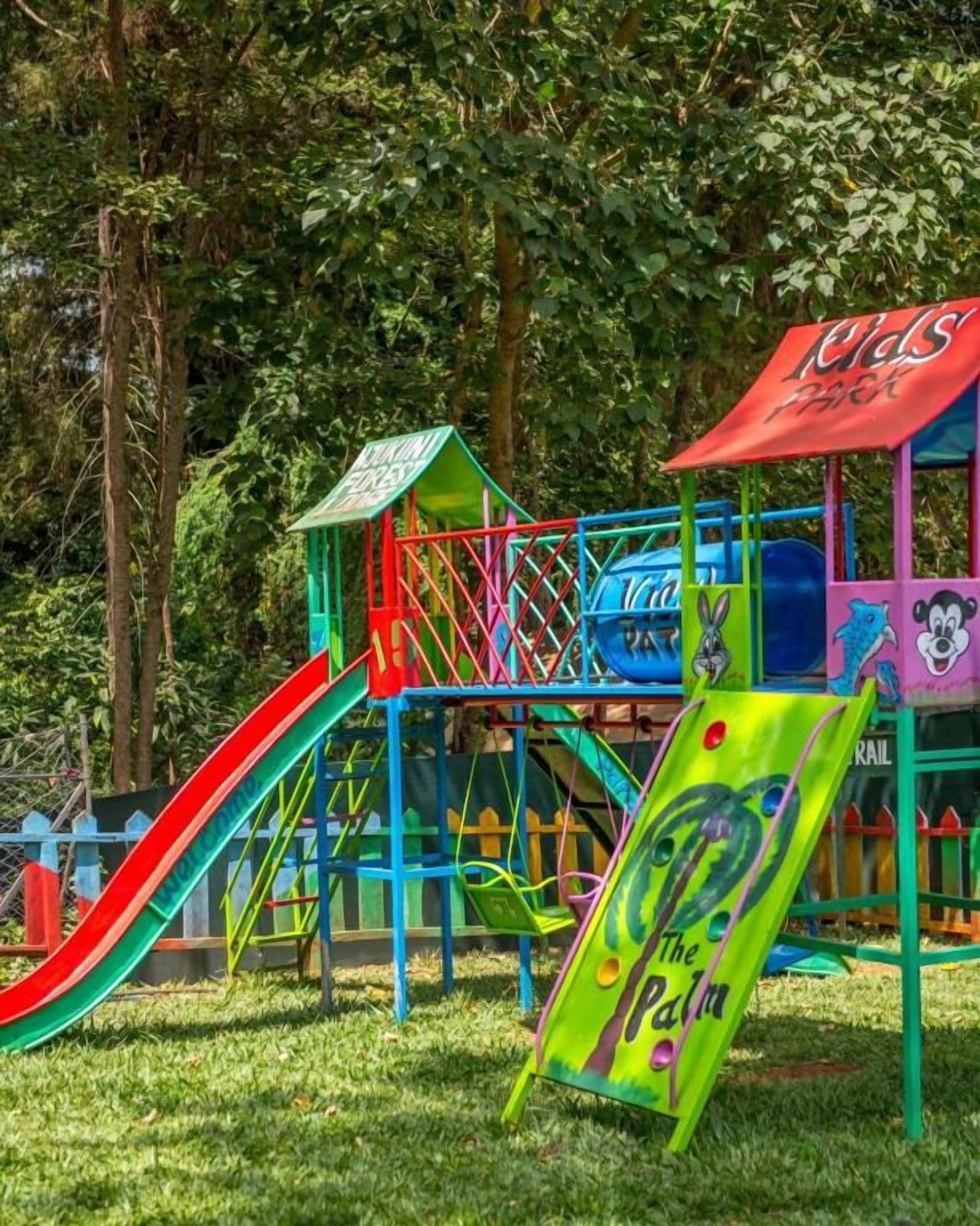 Un parque infantil con un tobogán, estructuras para escalar y un cartel que dice 'The Palm'.