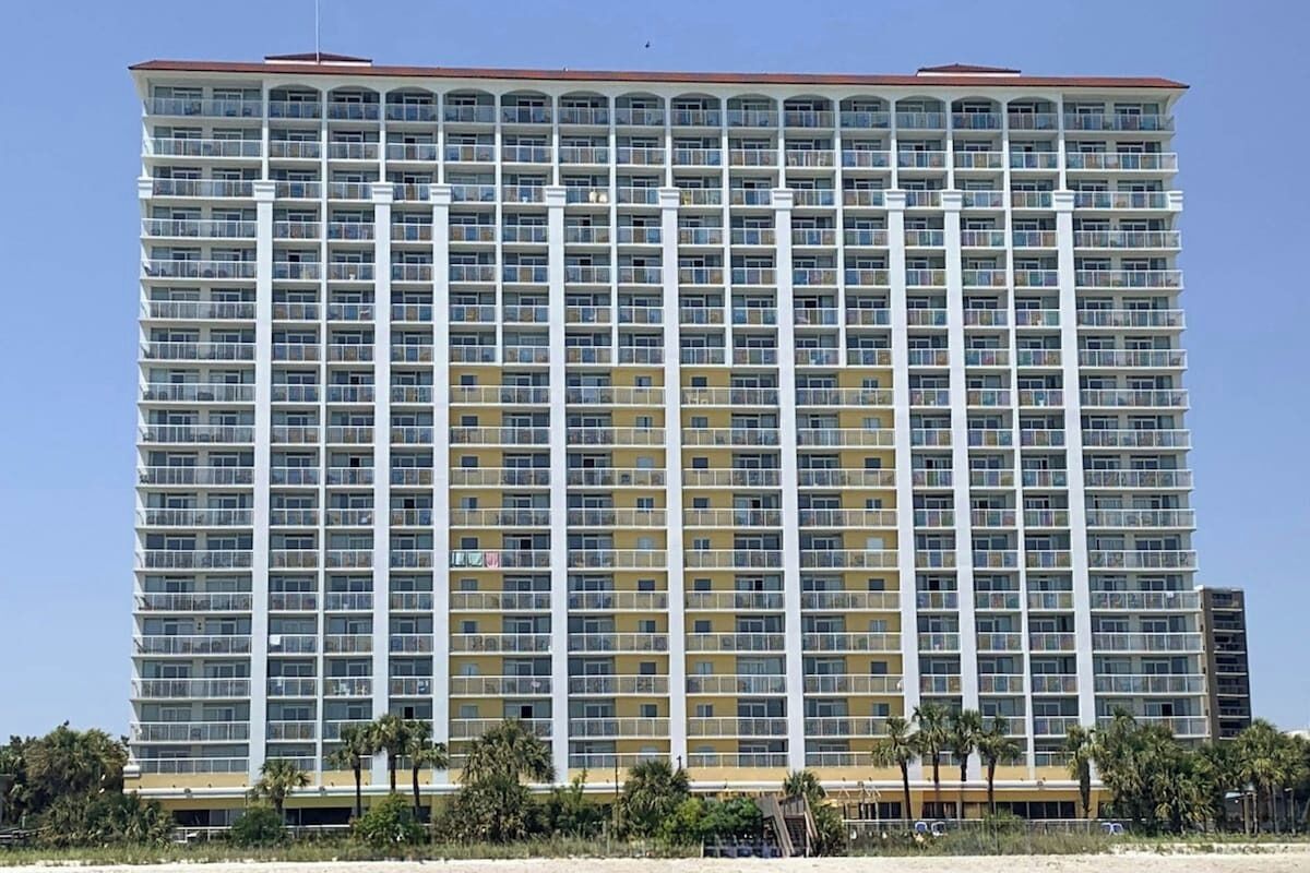 A high-rise hotel with multiple floors, balconies, and a flat roof. - Camelot by the Sea 1603 (Myrtle Beach)