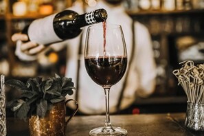 Um bartender servindo vinho em um copo.