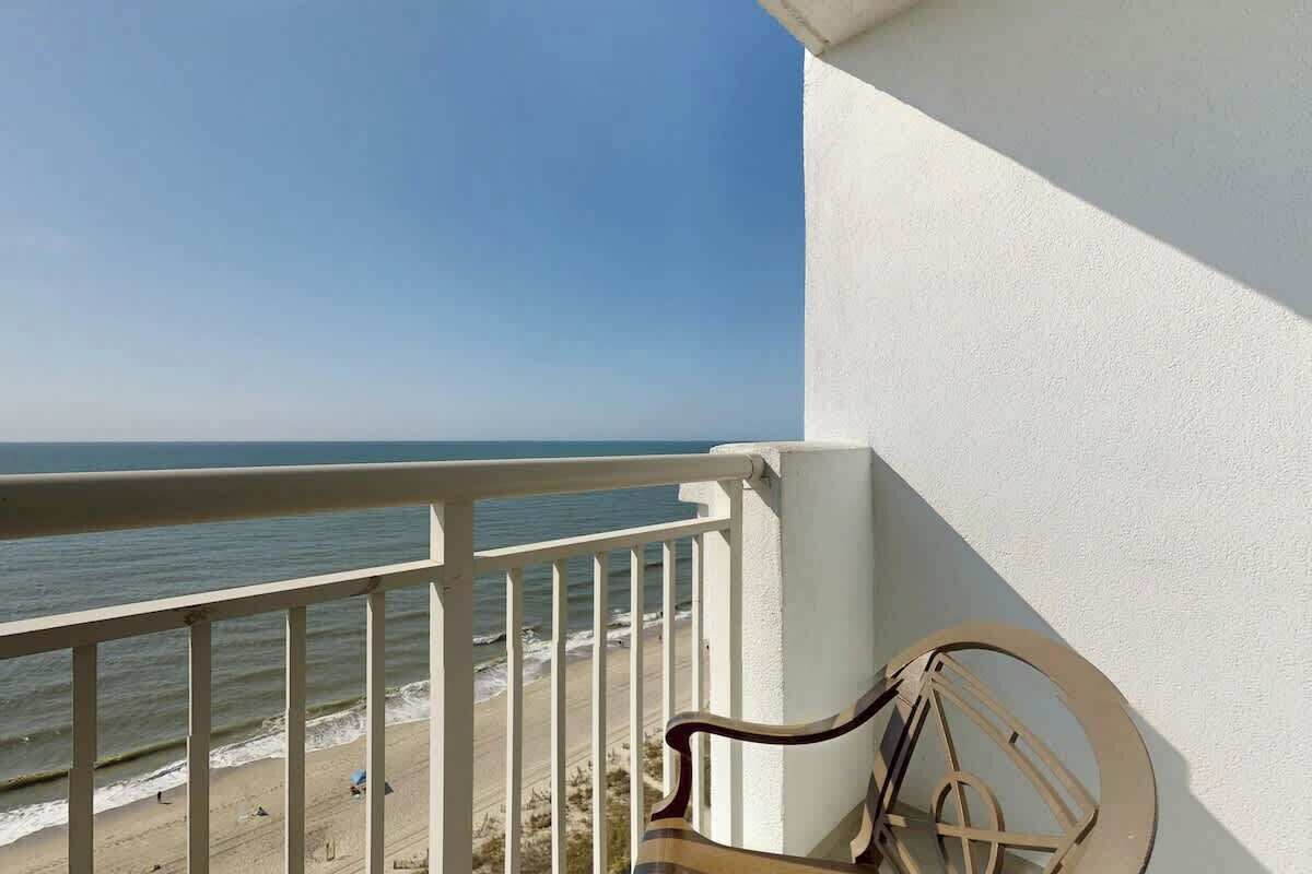 Ein Balkon mit Blick auf Strand und Meer.