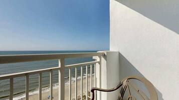 Ein Balkon mit Blick auf Strand und Meer.