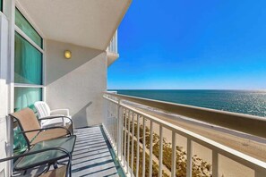 A balcony with a view of the ocean, a table with chairs, and a railing. - Oceanfront Luxe | Carolinian Eleven Thirty-Two (Myrtle Beach)