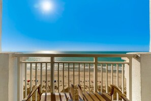 Ein Balkon mit Blick auf Strand und Meer.