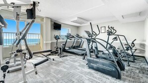 A gym with treadmills, ellipticals, and weight machines. - Camelot by the Sea 1704 (Myrtle Beach)