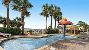 A pool with a 6-inch depth marker, surrounded by palm trees and a gazebo with a crown-shaped top. - Camelot by the Sea 1704 (Myrtle Beach)