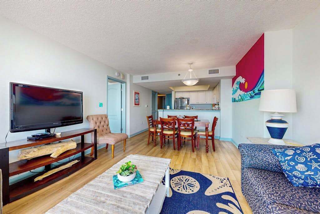 A living room with a television, sofa, and dining area.